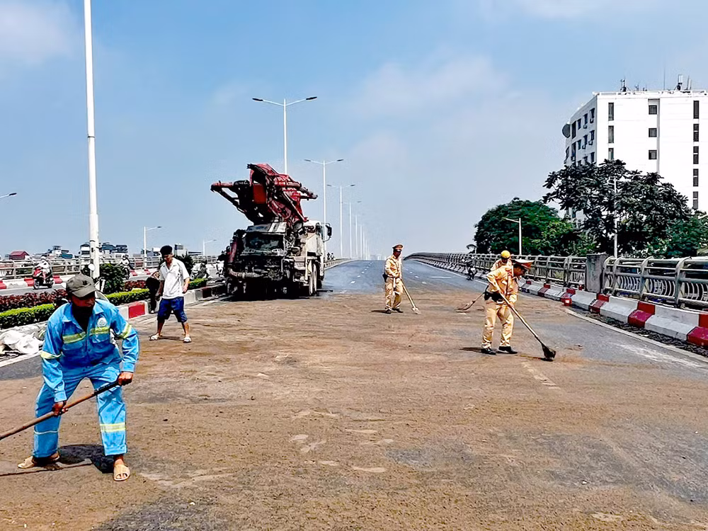 Trên đường tuần tra, CSGT xử lý vết dầu loang giúp dân đi lại an toàn -0