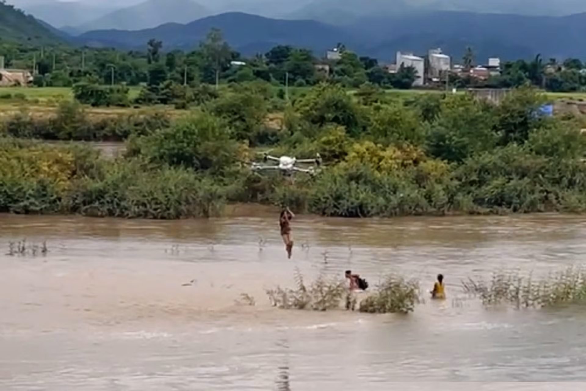 Dùng máy bay điều khiển giải cứu 2 em nhỏ mắc kẹt giữa sông nước xiết -0