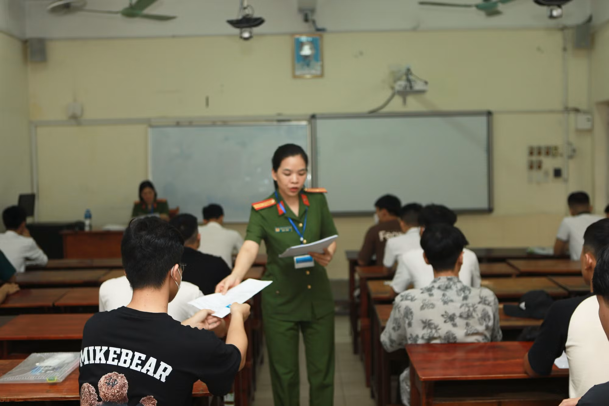 Cán bộ coi thi phát phiếu dự thi cho thí sinh rà soát lại thông tin.