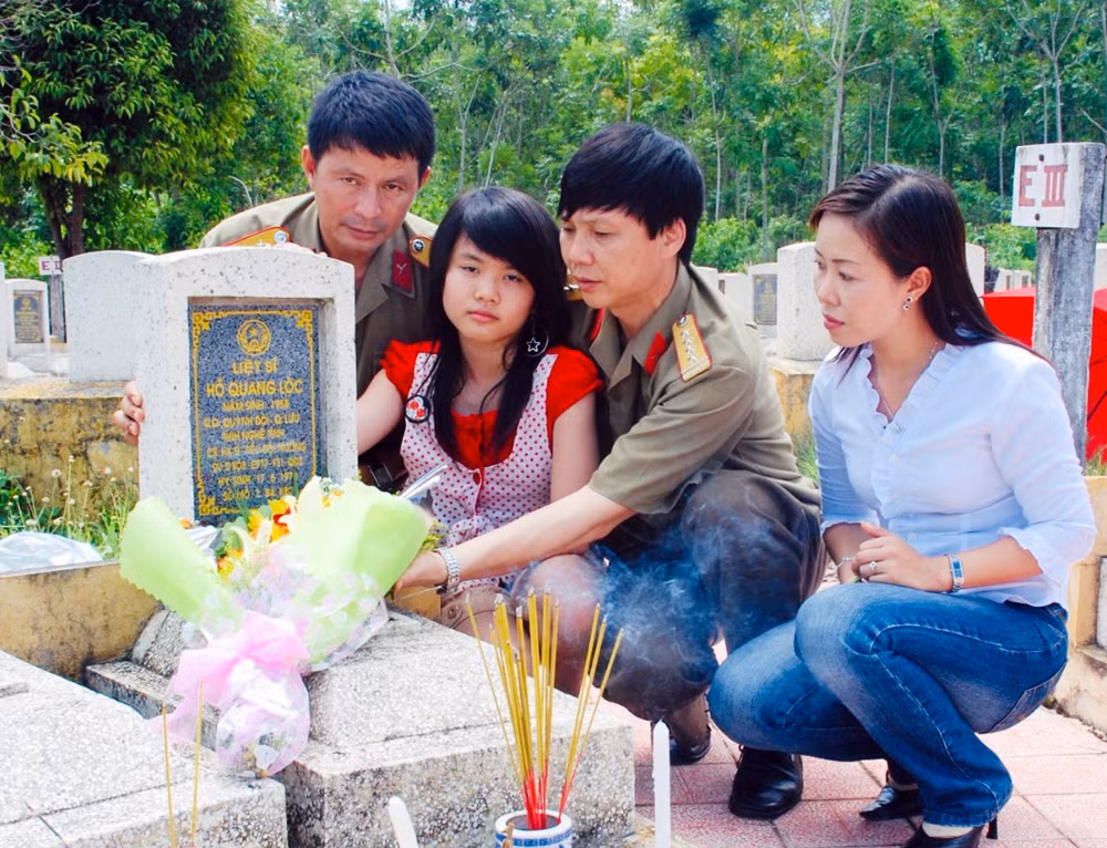 trang 10 - tác giả cùng con gái và nhà báo đoàn hoài trung, nhà báo vân anh bên mộ liệt sỹ hồ quang lộc.jpg -1
