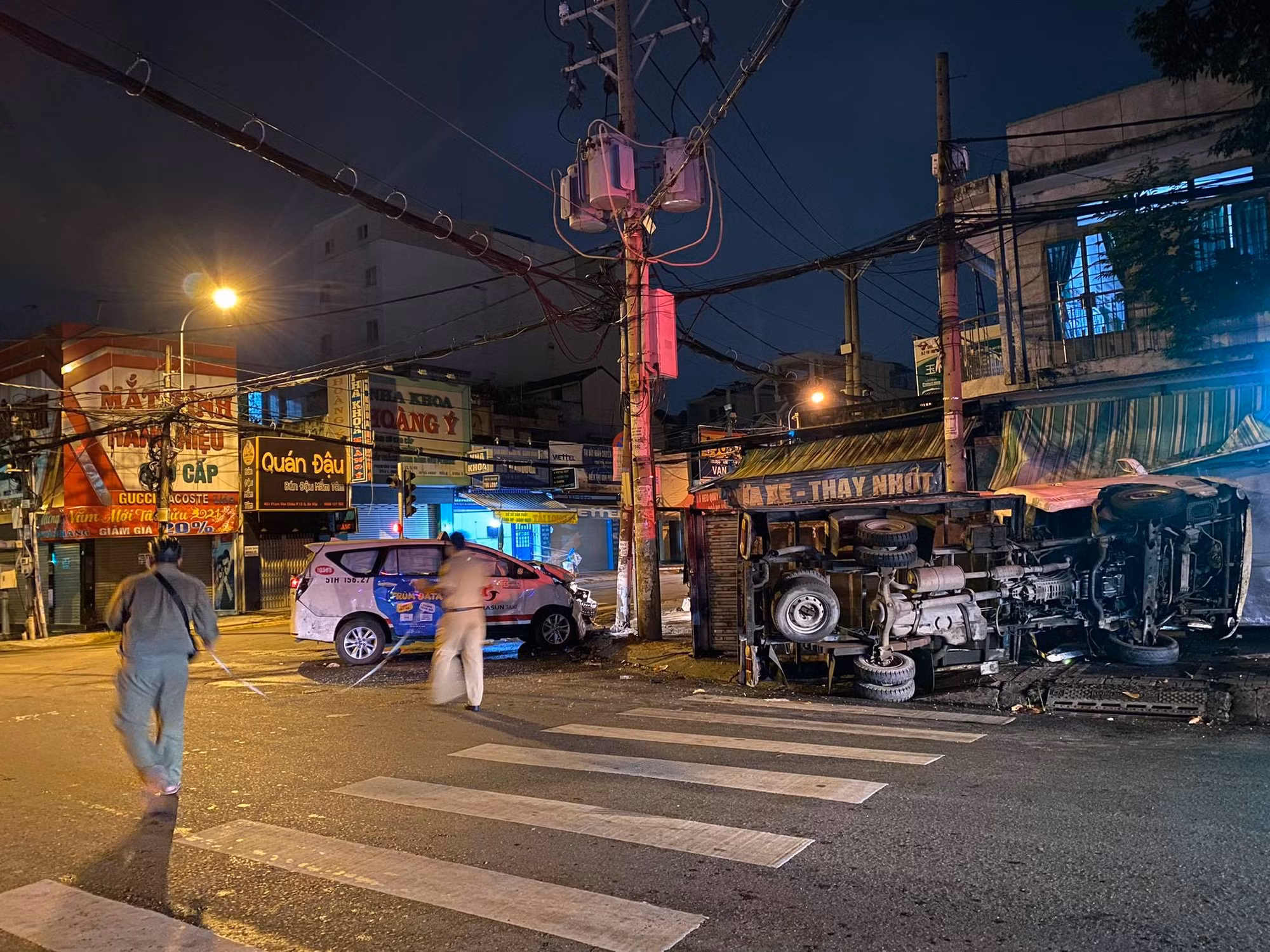 Xe tải lật ngang sau khi tông trúng xe taxi chở khách vượt đèn đỏ -0