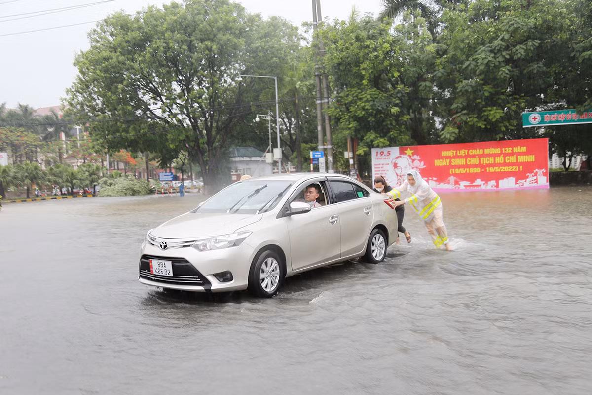 Hỗ trợ người dân đi qua các đoạn đường bị ngập úng sau trận mưa lớn -5
