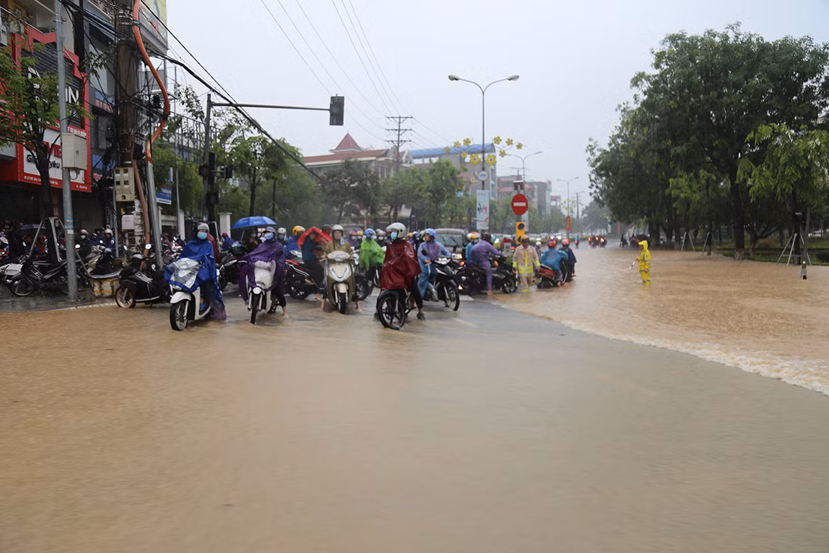 Hỗ trợ người dân đi qua các đoạn đường bị ngập úng sau trận mưa lớn -6