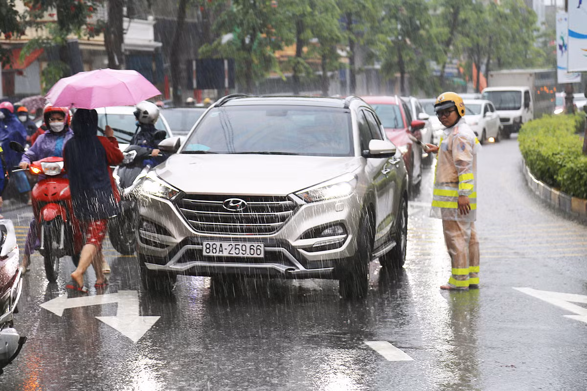 Hỗ trợ người dân đi qua các đoạn đường bị ngập úng sau trận mưa lớn -2