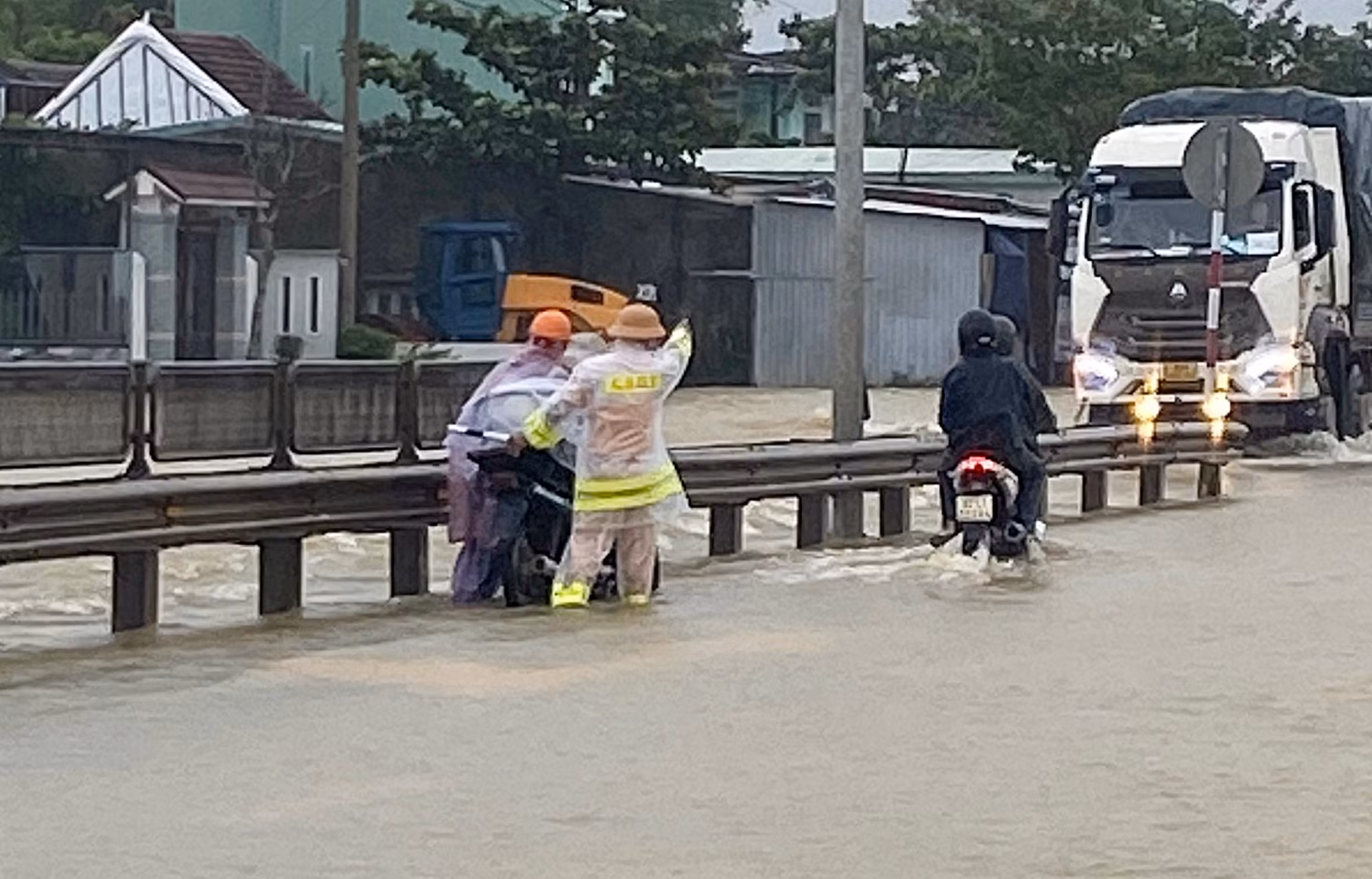 Nước lũ tràn qua QL1A, lực lượng CSGT làm “cọc tiêu sống” hướng dẫn giao thông -0