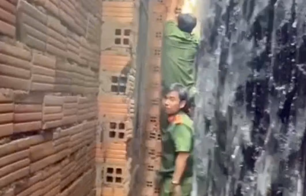 20 phút nghẹt thở giải cứu bé trai mắc kẹt giữa vách 2 căn nhà -0