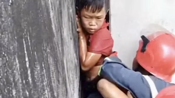 20 phút nghẹt thở giải cứu bé trai mắc kẹt giữa vách 2 căn nhà