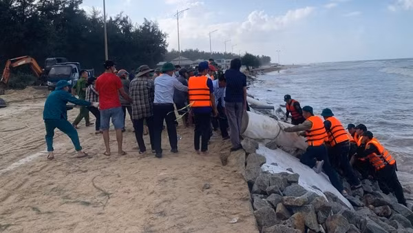 Hàng trăm người cùng đắp đá làm kè chống sạt lở bờ biển ở Huế