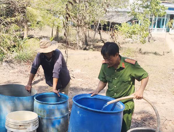 Công an xã đội nắng đưa nước sạch đến với người dân -0