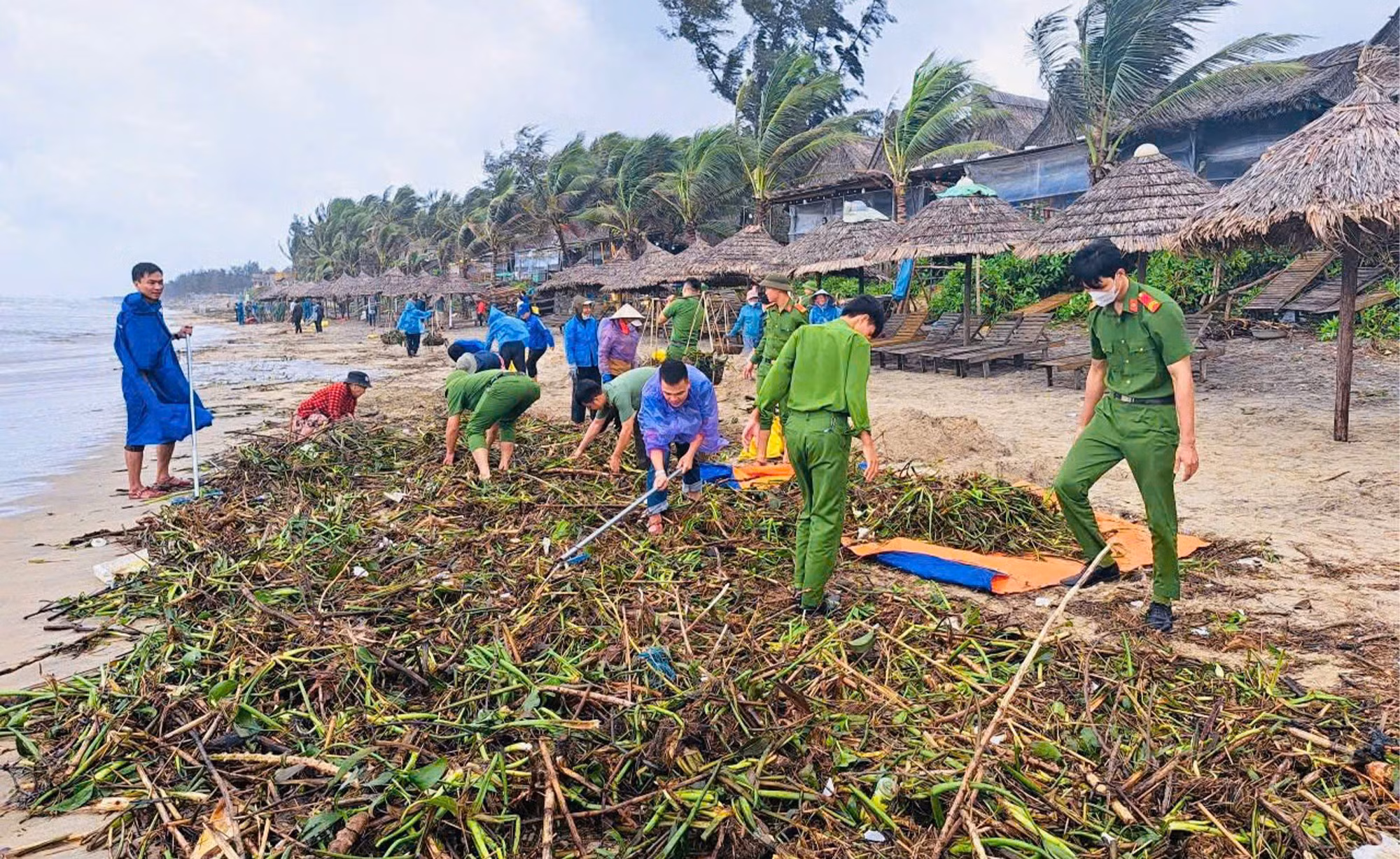 Công an Hội An hỗ trợ người dân làm sạch bãi biển du lịch bị rác lũ tấn công -0