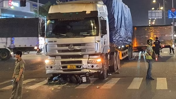 Xe máy băng ngang đường bị xe đầu kéo cuốn vào gầm