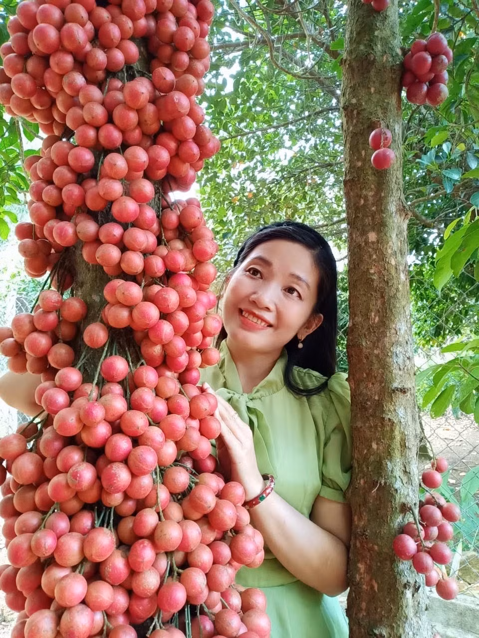 Nhà văn, nhà giáo Lý Thị Thủy bên cây đỏ ở vùng miền núi Phú Yên.