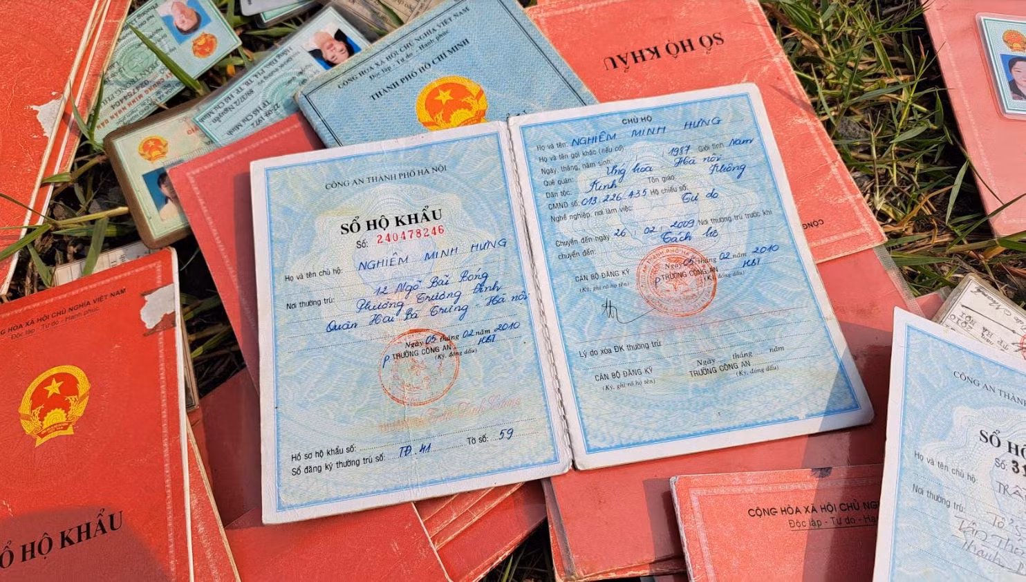 Hàng chục sổ hộ khẩu, CMND, con dấu tròn và Quốc huy Công an trên đường dân sinh -0