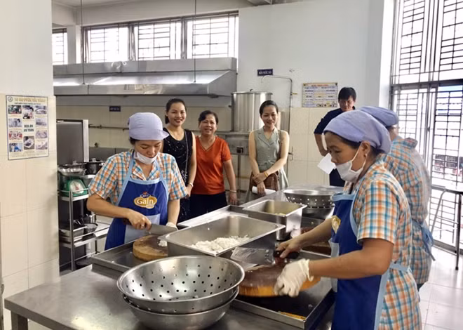 Phụ huynh thăm quy trình chế biến thức ăn tại bếp ăn trường học. Ảnh minh họa