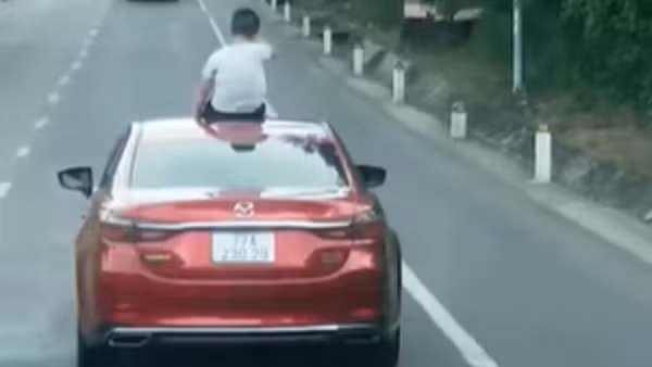 Bị tước GPLX 2 tháng vì để con ngồi trên nóc xe khi đang lưu thông