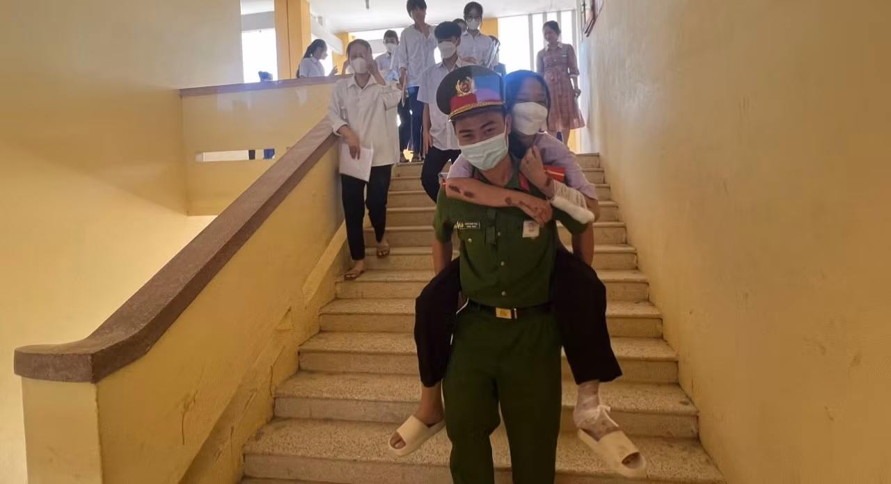 Cõng thí sinh ngồi xe lăn ra vào phòng thi -1