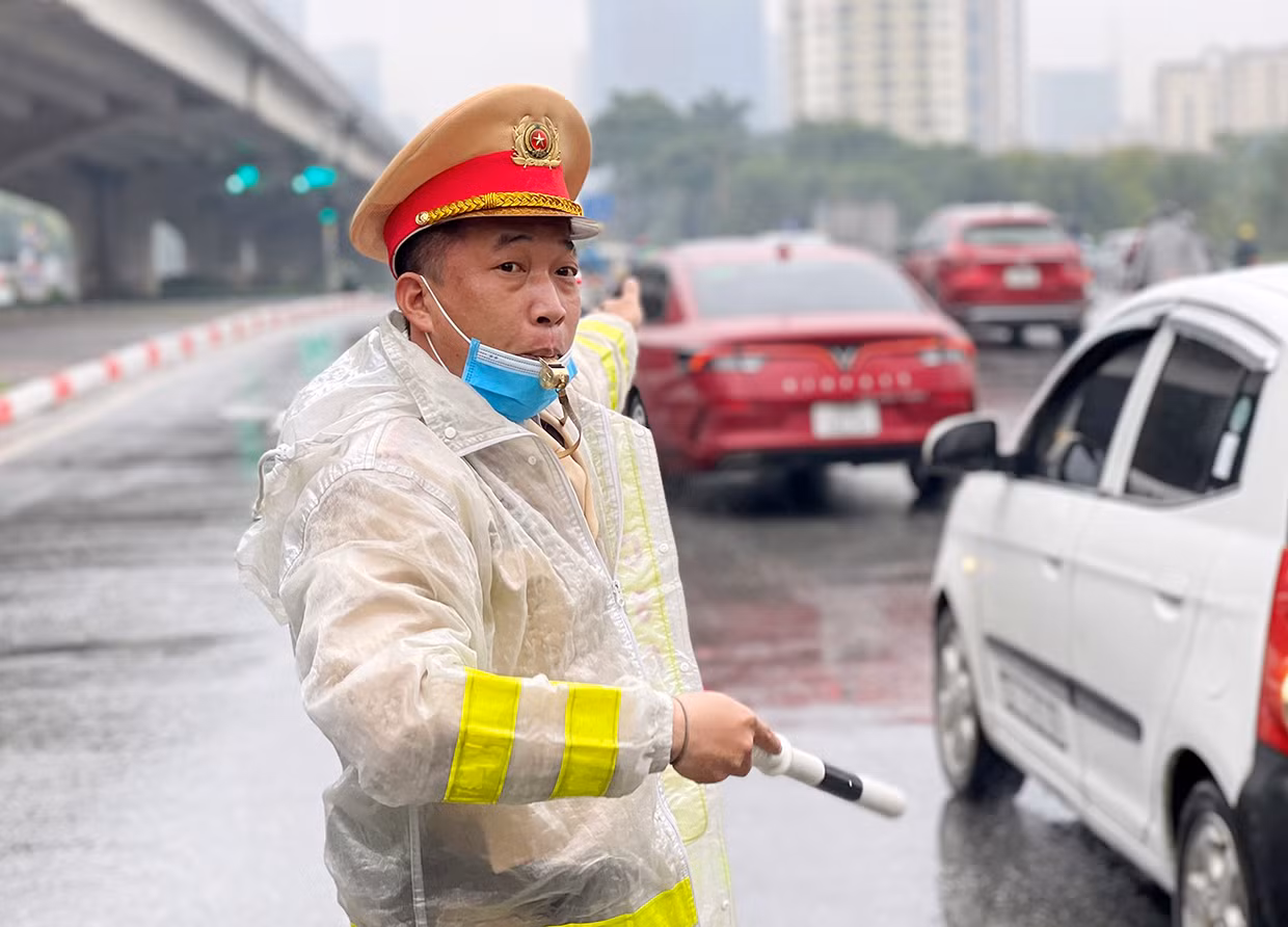 CSGT chốt trực trong mưa rét điều tiết giao thông đón người dân trở về Thủ đô -0