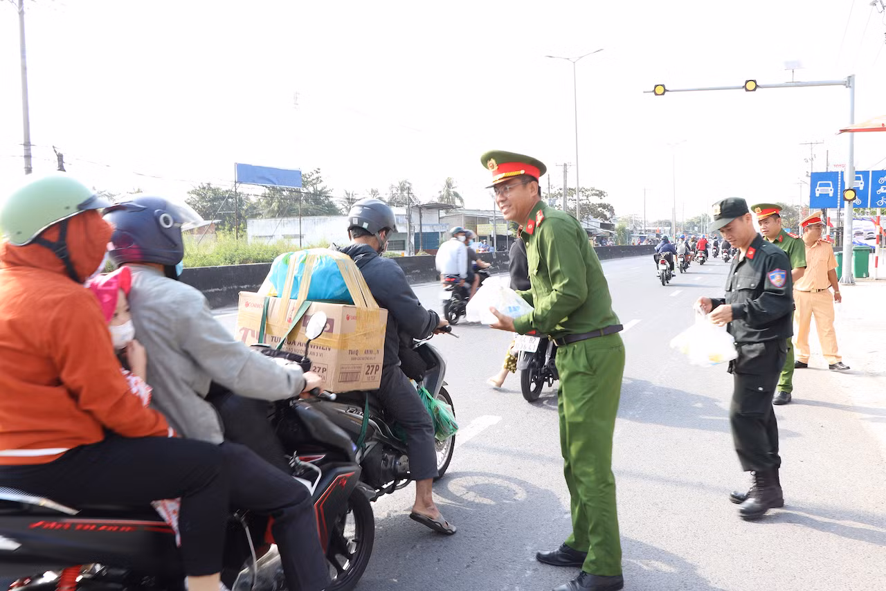 CSGT phát nước suối miễn phí, khăn lạnh tặng người dân trên đường về quê đón Tết -0