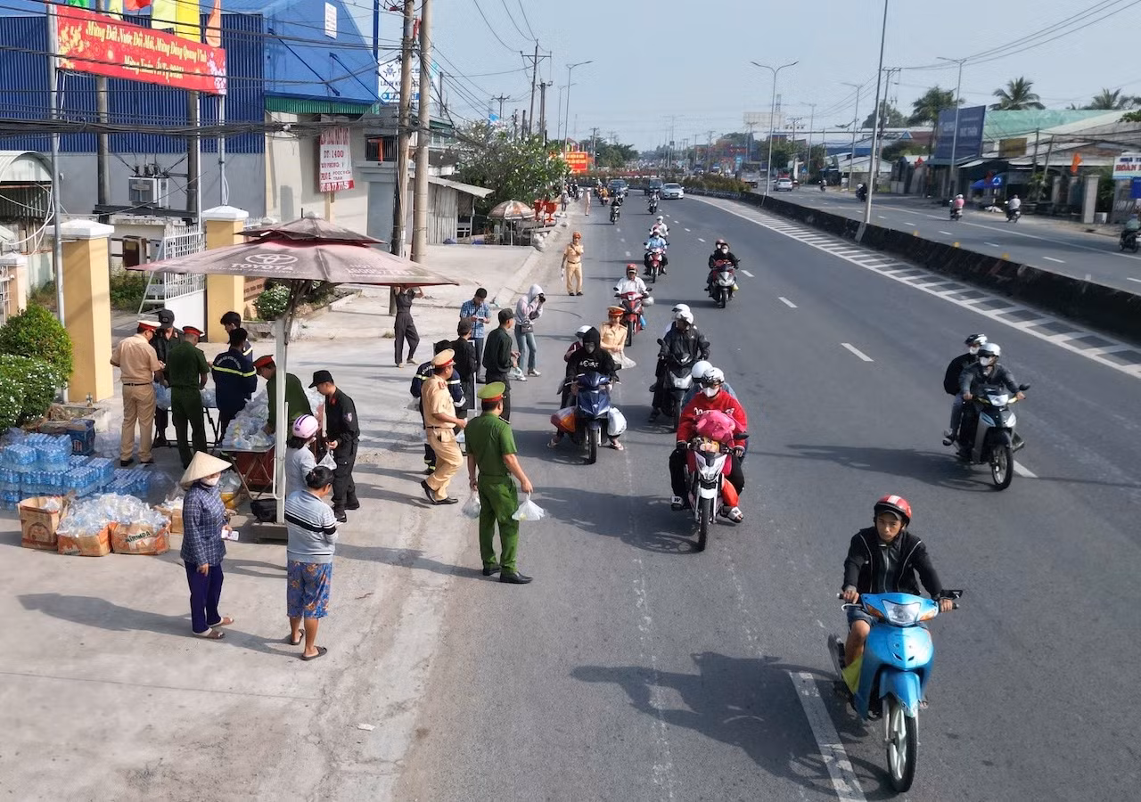 CSGT phát nước suối miễn phí, khăn lạnh tặng người dân trên đường về quê đón Tết -0