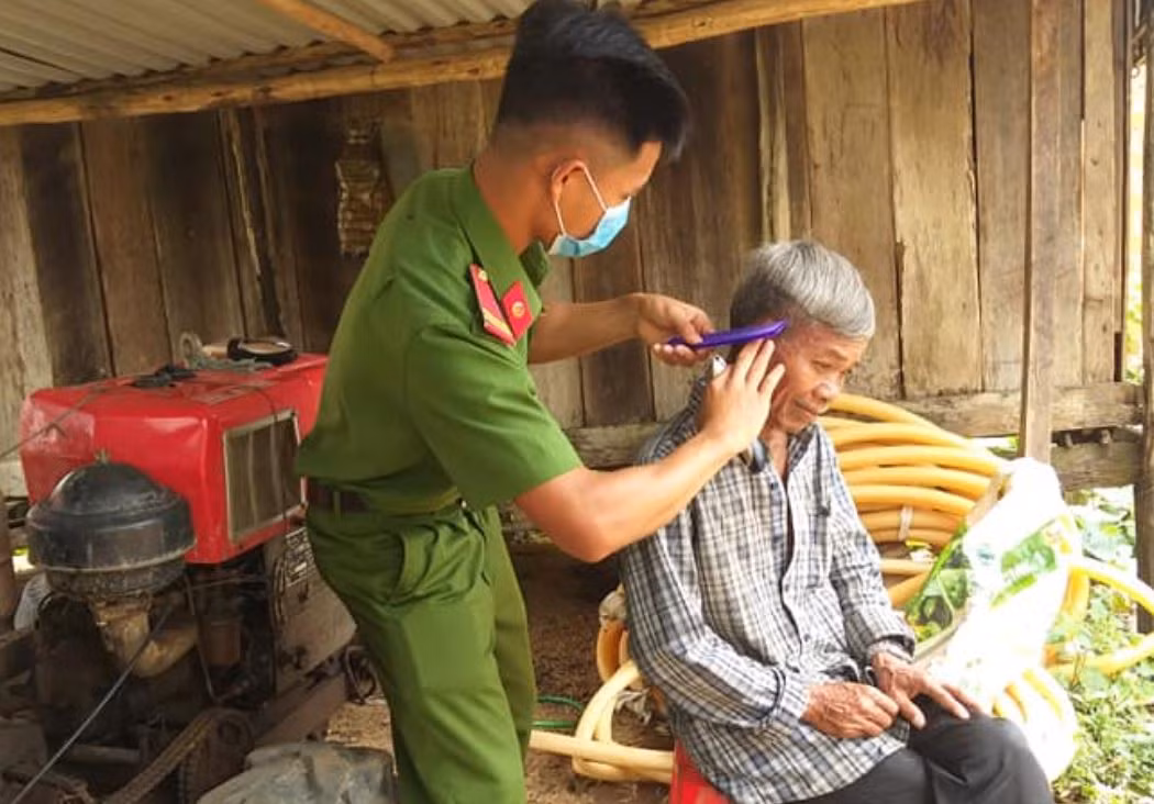 Công an huyện Mang Yang về làng cắt tóc, tuyên truyền pháp luật cho dân -1