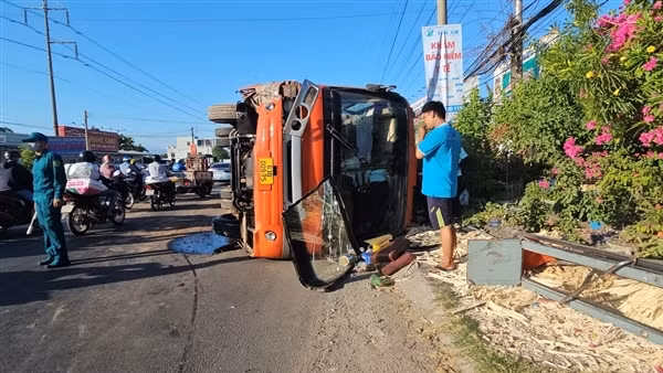 Xe máy đột ngột băng ngang đường khiến xe ô tô đưa đón công nhân lật ngang
