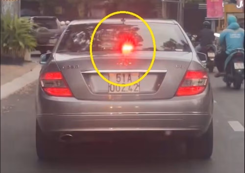 Đang xác minh xe ô tô biển trắng bật đèn ưu tiên khi lưu thông trên đường -0