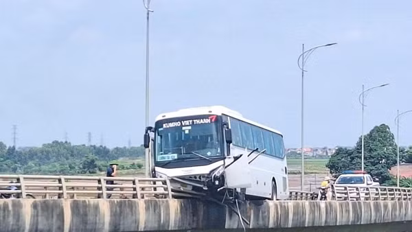 Xe ô tô 45 chỗ nằm vắt vẻo trên lan can cầu Bình Than sau tai nạn