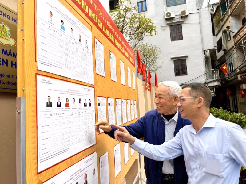 Người dân nghiên cứu danh sách ứng cử viên Quốc hội và HĐND các cấp trước khi bỏ phiếu.