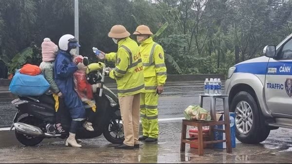 CSGT đội mưa tiếp đồ ăn, thức uống cho người dân