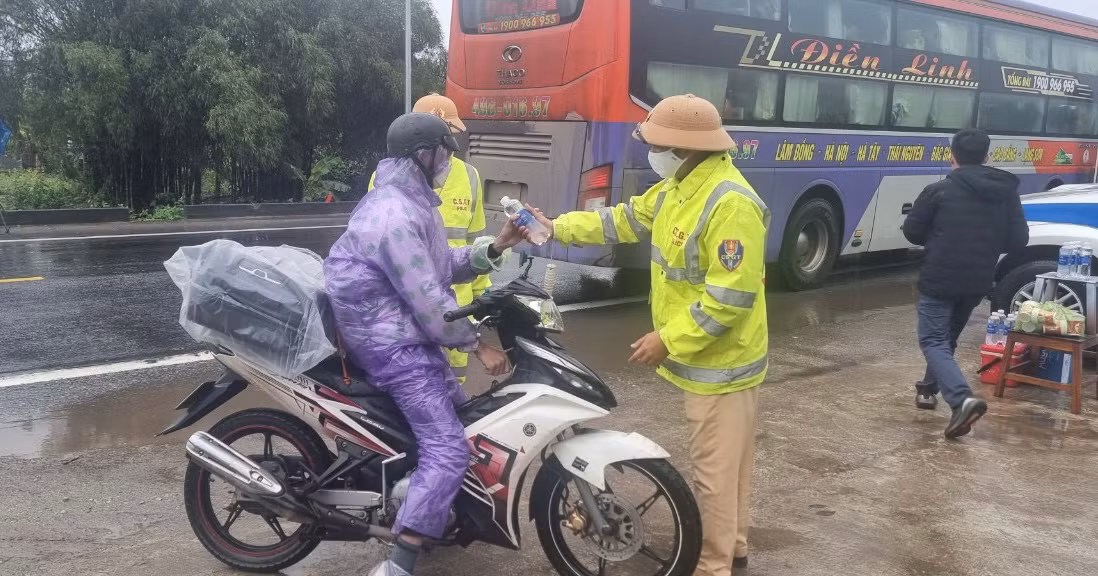 CSGT đội mưa tiếp đồ ăn, thức uống cho người dân trở lại miền Nam làm việc sau Tết -0