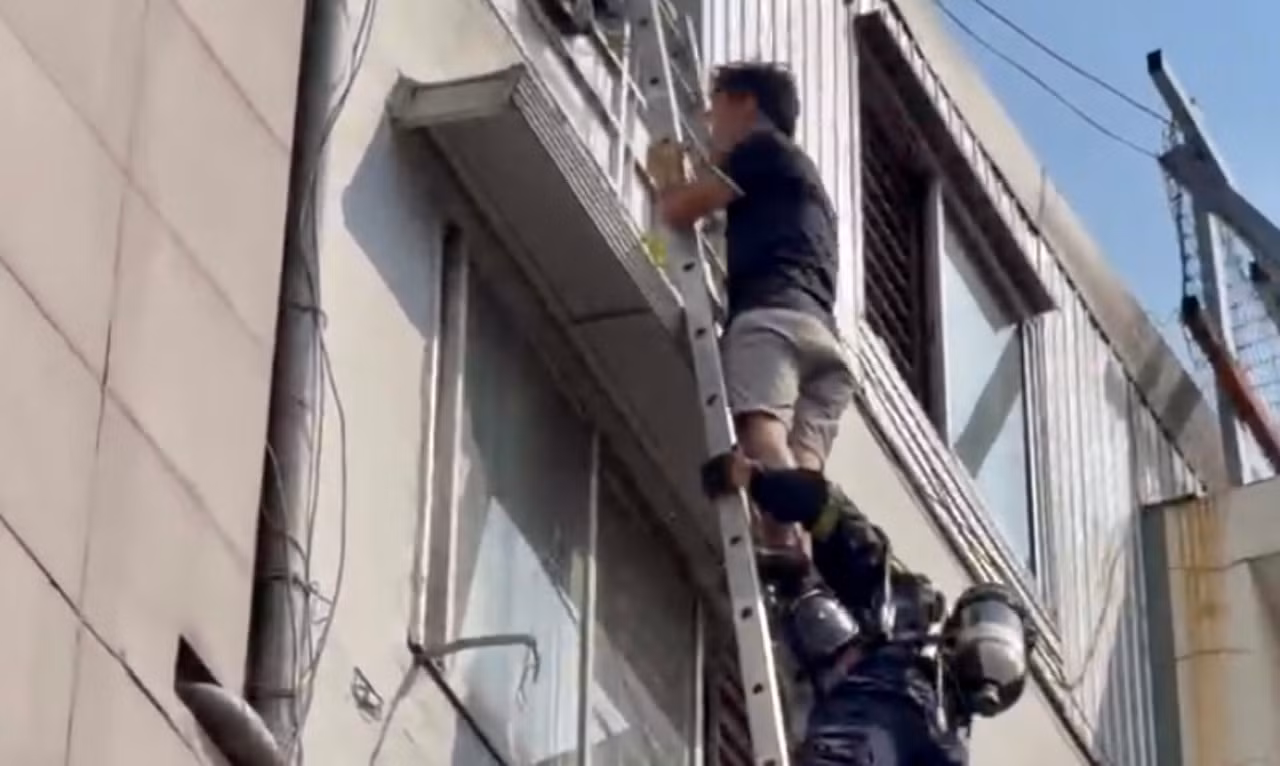 Cảnh sát bắc thang giải cứu 3 người thoát khỏi đám cháy nhà cao tầng -1