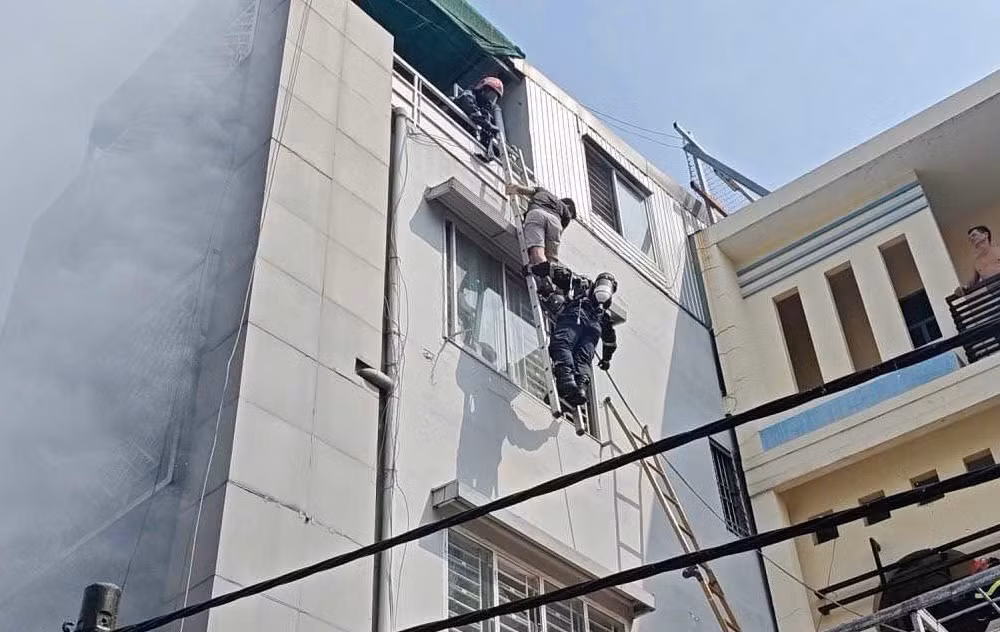Cảnh sát bắc thang giải cứu 3 người thoát khỏi đám cháy nhà cao tầng -0