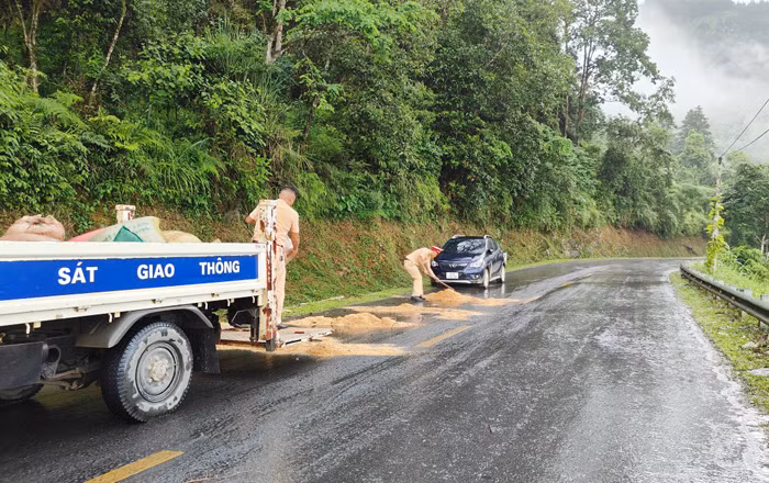 CSGT Công an huyện Bắc Hà xử lý vết dầu loang trên đường giúp dân đi lại an toàn -0