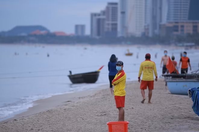 Lực lượng cứu hộ, cứu nạn bãi biển Phạm Văn Đồng nhắc nhở người dân thực hiện nghiêm túc các quy định an toàn phòng chống dịch và không tụ tập thành nhóm đông người.