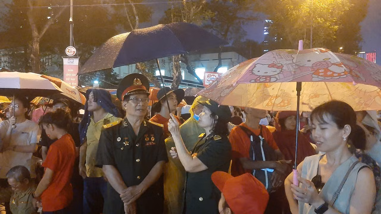 Người dân đội mưa đứng chờ xem diễu binh, diễu hành -0