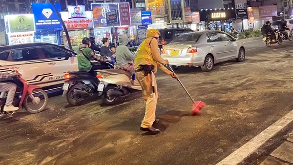 CSGT dùng cát ngăn vết dầu loang, giúp người dân đi xe an toàn