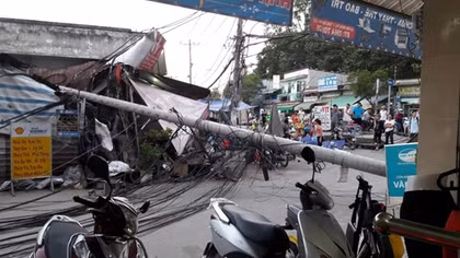 Cột điện ngã đè tiệm sửa xe, chắn ngang đường