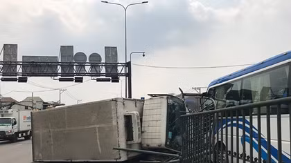Sụp ổ gà, xe tải tông dải phân cách lật ngang rồi va chạm với xe khách
