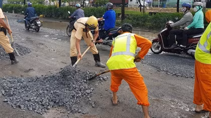 CSGT lấp đá khắc phục đường ổ gà, ổ voi