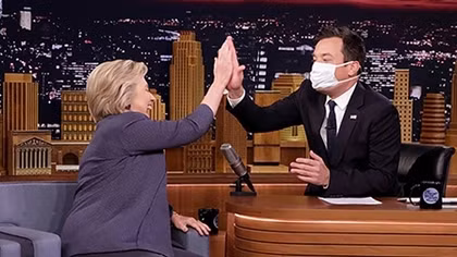 Người dẫn chương trình đeo khẩu trang khi đối thoại với Hilary Clinton