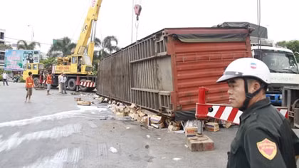 Xe container lật, hàng ngàn thùng sữa ‘lăn’ trên đường