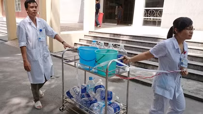 Bệnh nhân vác chai lọ xếp hàng cùng bác sĩ chờ nước sạch