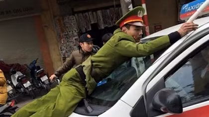 Tạm giữ hình sự lái xe taxi hất cảnh sát lên nắp ca pô