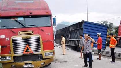 Xe đầu kéo cuốn 40m dải phân cách, lật thùng container xuống đường
