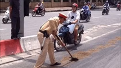 Cảnh sát giao thông dọn dầu loang trên đường