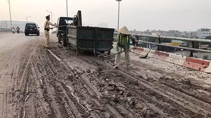 CSGT dọn bùn đất rơi vãi trên đường 