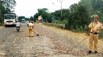 CSGT thu dọn đá dăm trên đường Quốc lộ 19
