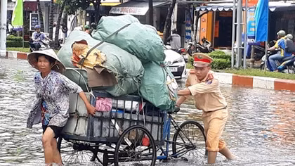 Cảnh sát giao thông giúp dân qua những đoạn đường ngập sâu 
