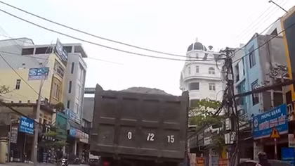 Mở cửa ôtô bất cẩn, hai em nhỏ suýt nằm gầm xe tải