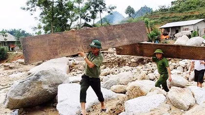 Cán bộ Công an dầm mình trong mưa giúp dân vùng lũ